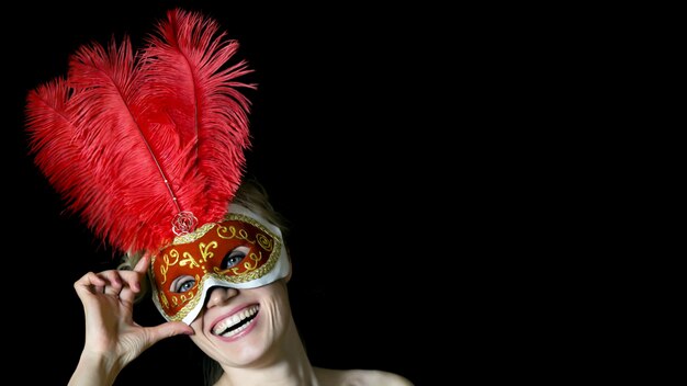 Fille au masque avec des plumes au carnaval.