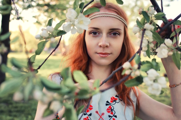 Une fille au printemps se promène dans l'allée des pommes au coucher du soleil du soir