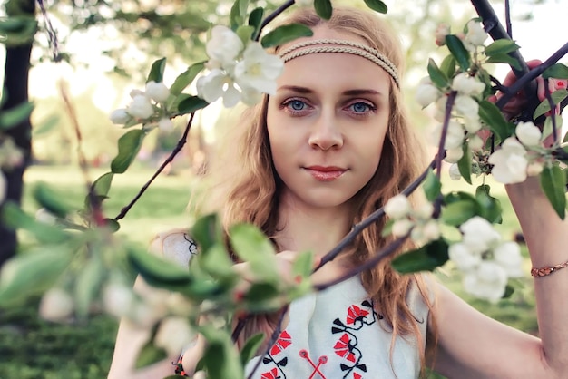 Une fille au printemps se promène dans l'allée des pommes au coucher du soleil du soir