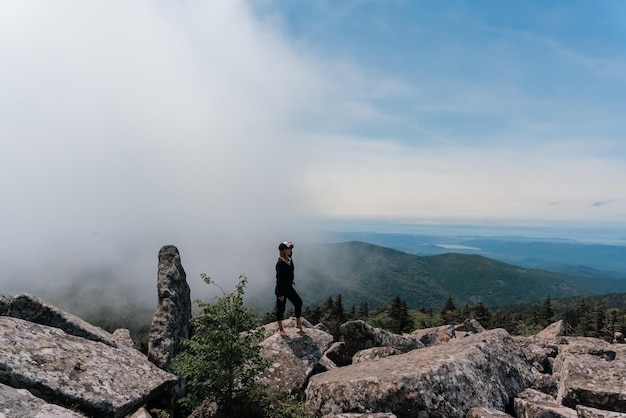 Une fille au sommet du mont Pidan regarde une belle vallée de montagne dans le brouillard en été Voyages et tourisme Randonnées