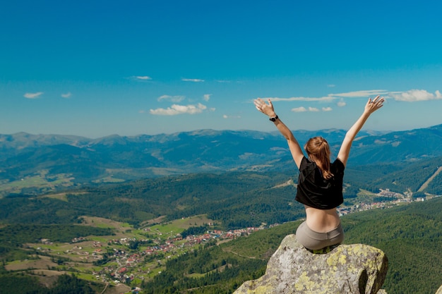 La fille au sommet de la montagne leva les mains