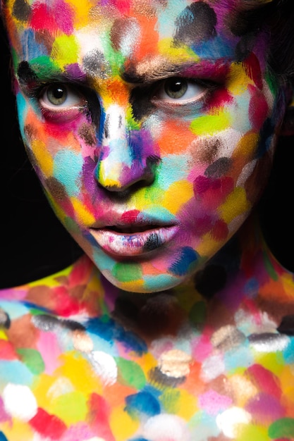 Fille au visage coloré peint. Image de beauté d'art.