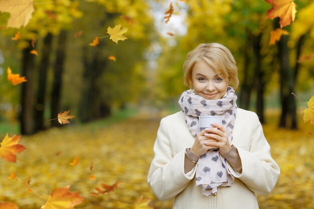 fille d'automne avec du thé dans le parc