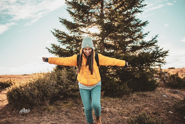 Une fille aux bras tendus qui traverse la nature