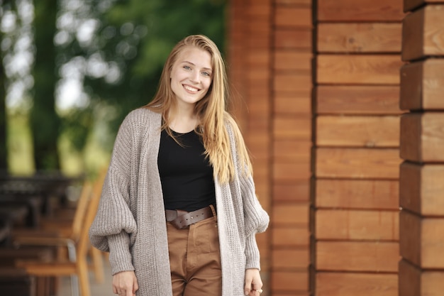 Une fille aux cheveux blonds et aux yeux bleus dans une veste blanche et un chemisier noir