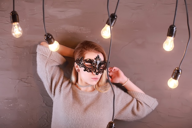 Une Fille Aux Cheveux Blonds Dans Un Masque Noir Pose