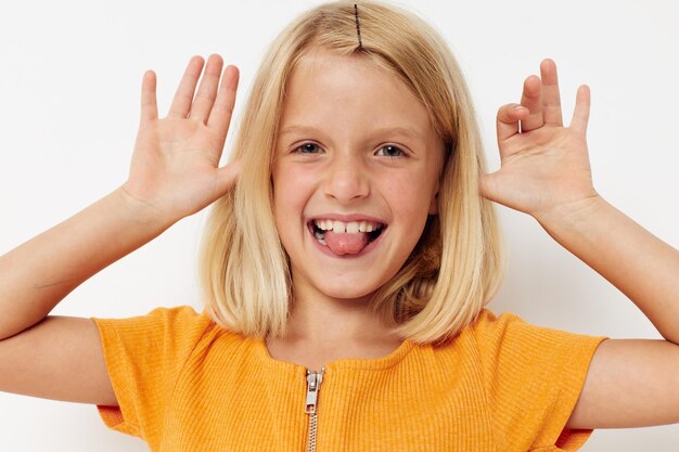 Fille aux cheveux blonds geste avec les mains posant gros plan