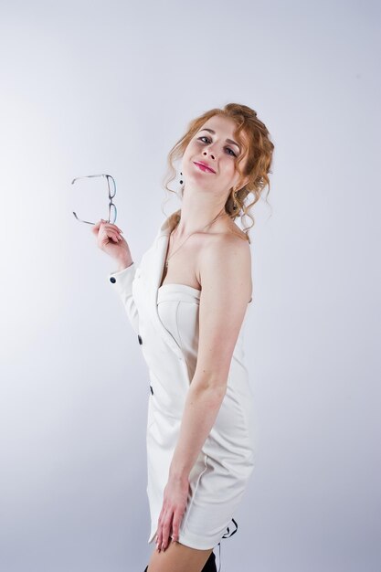 Fille aux cheveux bouclés dans des verres isolé sur fond de studio blanc