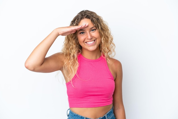 Fille aux cheveux bouclés isolé sur fond blanc saluant avec la main avec une expression heureuse