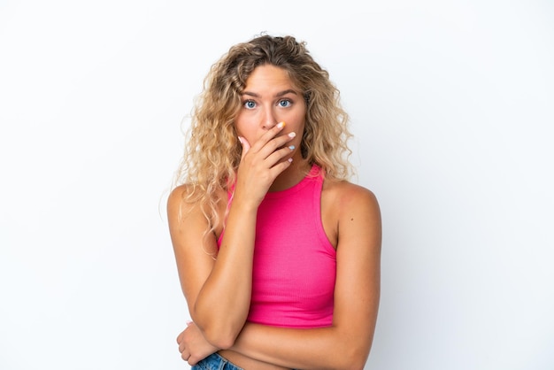 Fille aux cheveux bouclés isolé sur fond blanc surpris et choqué tout en regardant à droite