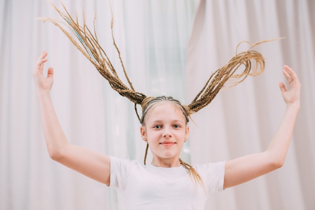 La fille aux cheveux bruns et aux tresses avec kanekalon tressé