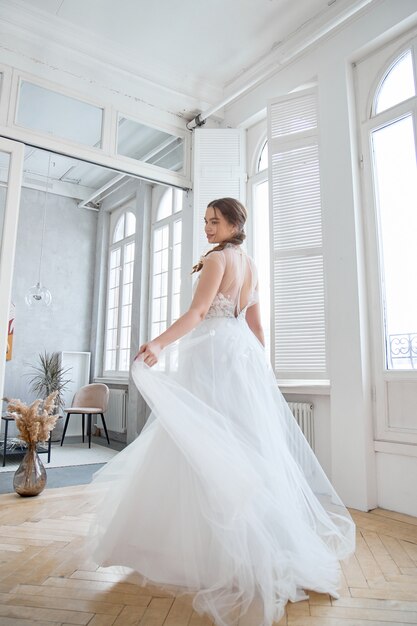 Fille aux cheveux bruns dans une belle robe de mariée blanche.