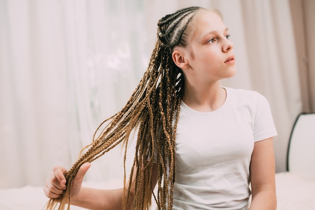 Fille aux cheveux bruns et nattes tressées avec des cheveux artificiels