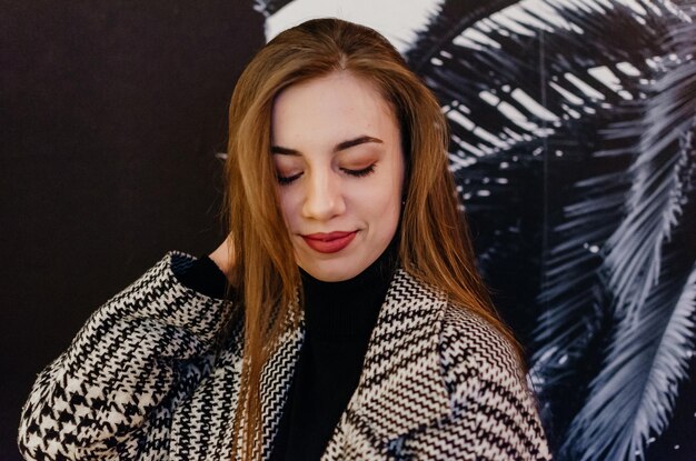 Une fille aux cheveux longs et un pull noir et blanc