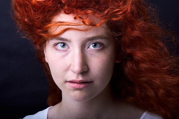 Fille aux cheveux rouge sur fond noir