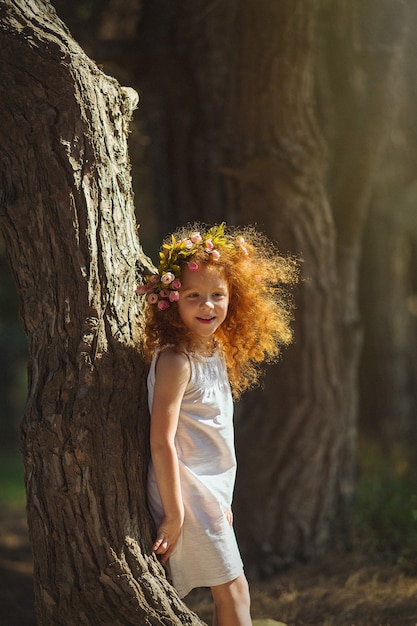 fille aux cheveux roux jouant dans les bois