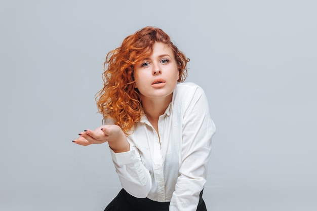 La fille aux cheveux roux lève les mains avec surprise