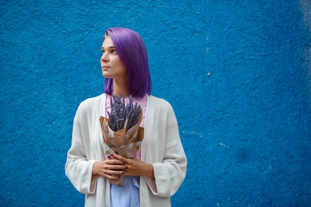 Fille aux cheveux violets tient un bouquet de lavande