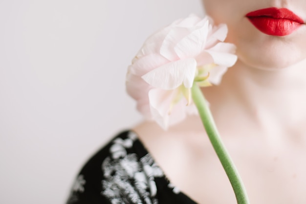 Fille aux lèvres rouges et une fleur