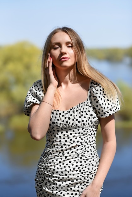 Fille aux yeux fermés se dresse sur le fond de la rivière