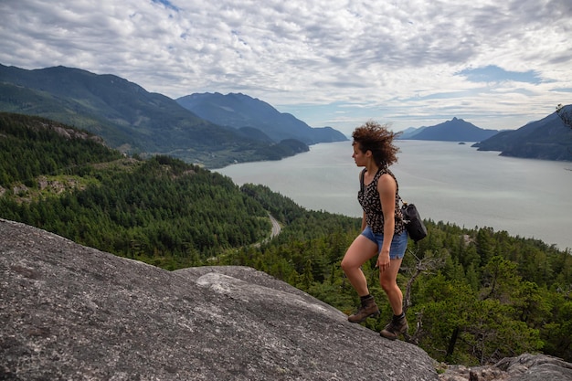 Fille aventureuse randonnée sur une montagne au cours d'une journée d'été animée