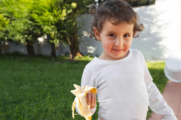 Photo fille ayant une collation de fruits dans le patio de sa maison