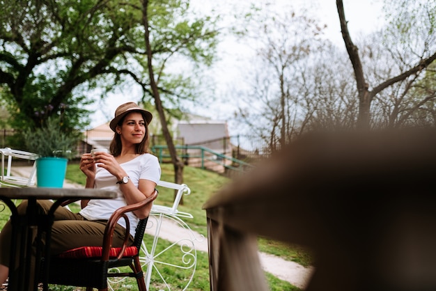 Fille ayant une tasse de café au café au parc.