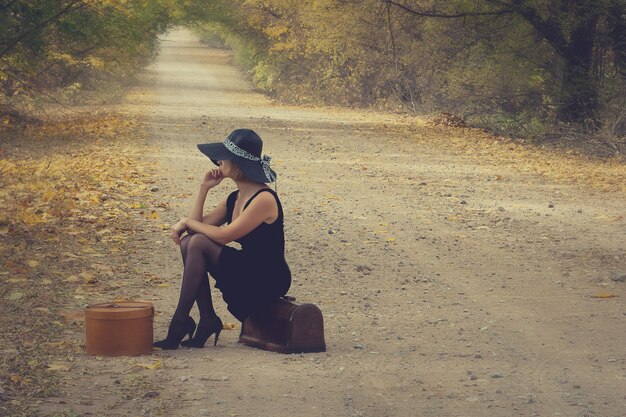 Fille avec bagages dans un style vintage