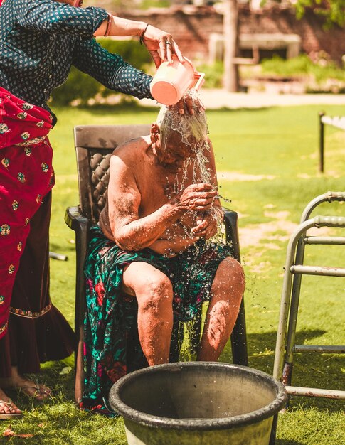 Photo fille baignant sa vieille mère dans le jardin