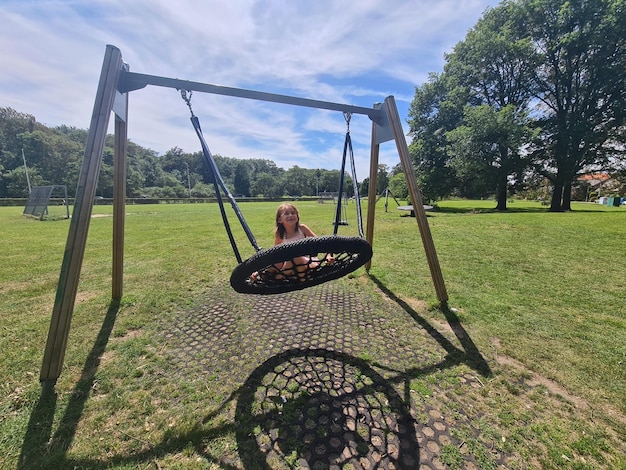 Une fille sur une balançoire dans un parc