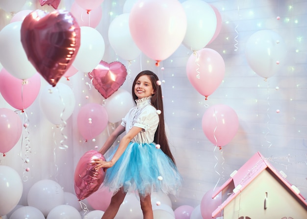 Fille avec des ballons à l'hélium rose et tutu