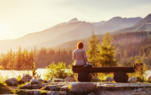 Fille sur un banc au coucher du soleil