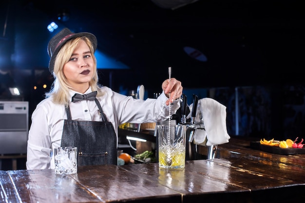 Fille barman concocte un cocktail au bar