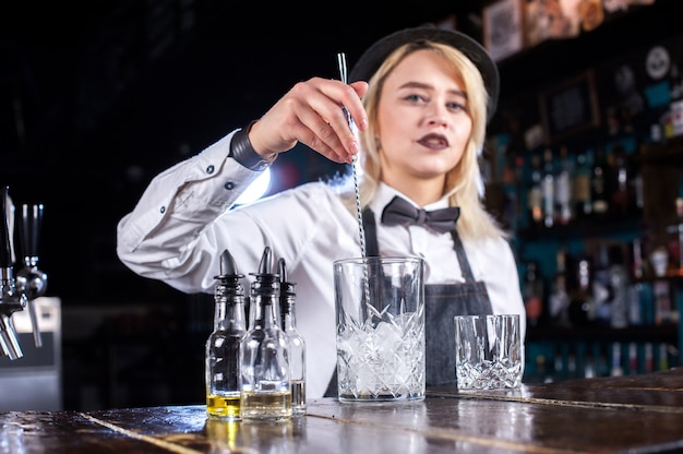 Photo fille barman concocte un cocktail sur la salle de la bière