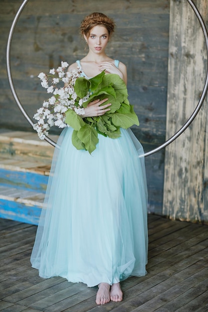 Fille avec un beau bouquet de fleurs dans une robe bleue