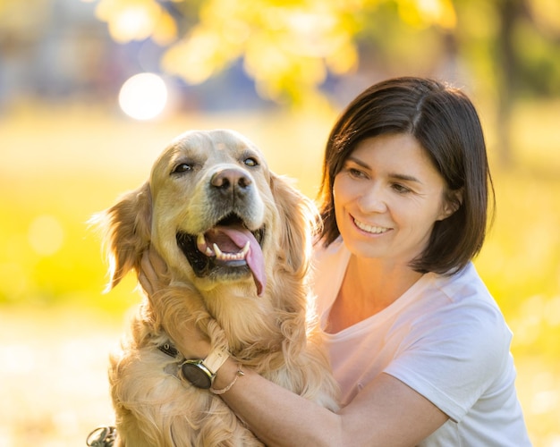 Fille avec un beau portrait de chien golden retriever sur un arrière-plan flou