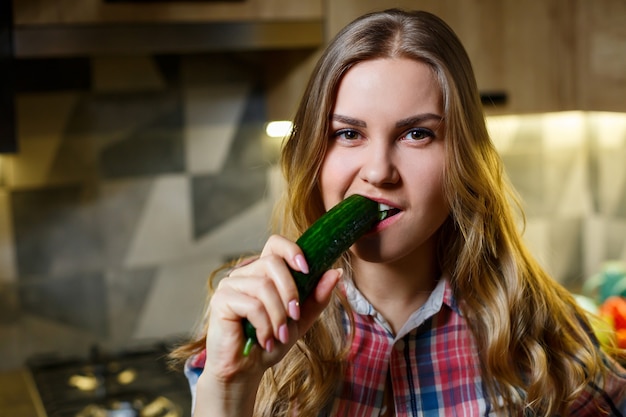 La fille avec la belle figure tient des légumes