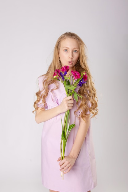 Fille avec de belles fleurs dans des vêtements violets