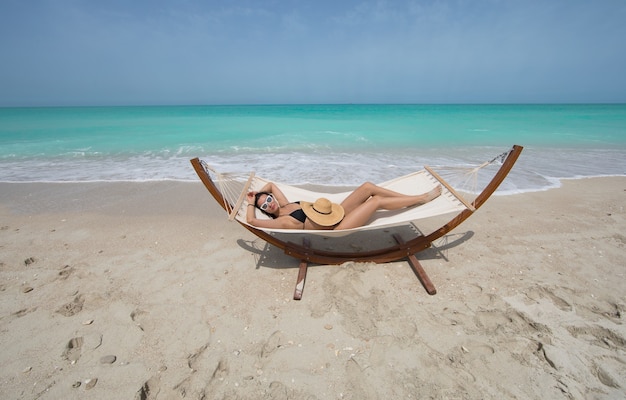 fille en bikini reposant sur une chaise longue