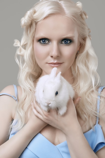 Photo fille blonde albinos en robe élégante posant avec mignon petit lapin