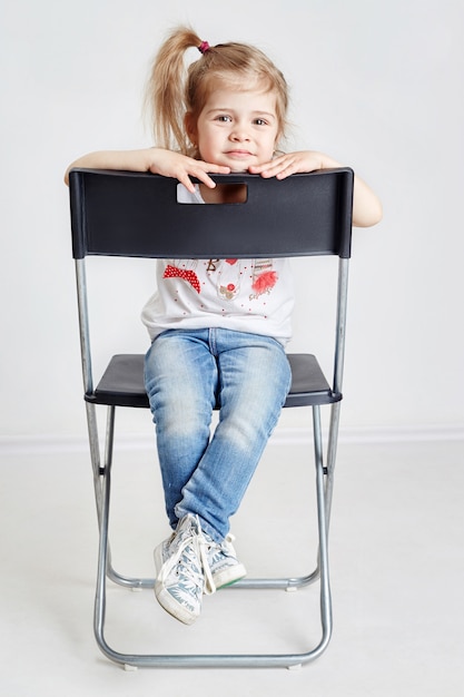 Fille blonde assise dans la chaise du directeur