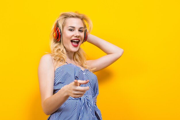 Fille blonde en blouse à rayures bleues avec un casque