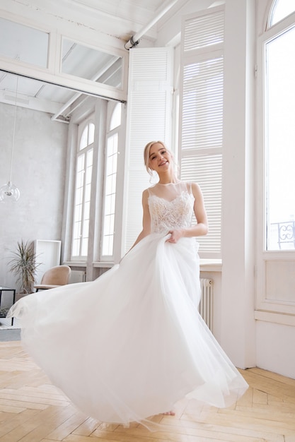 Fille blonde dans une belle robe de mariée blanche.