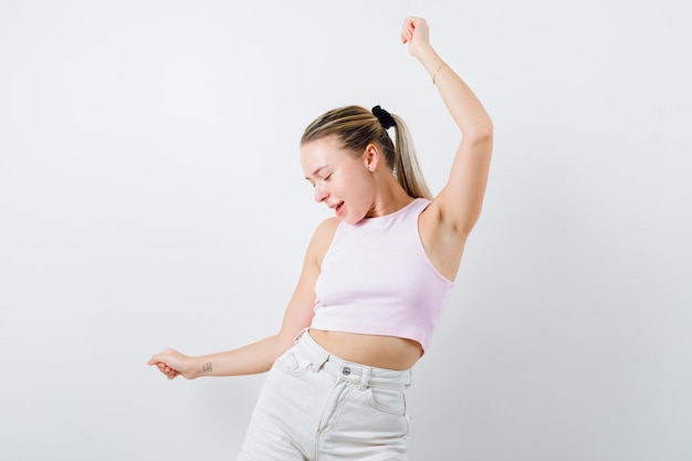 La fille blonde danse sur le fond blanc