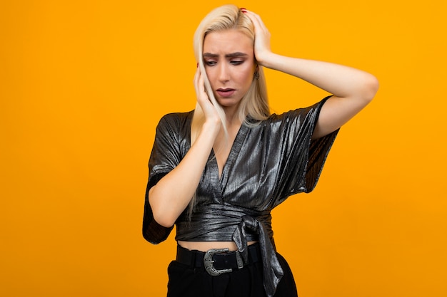 fille blonde émotionnelle sur un mur jaune