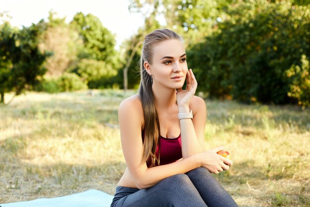 Fille blonde faisant des exercices dans le parc