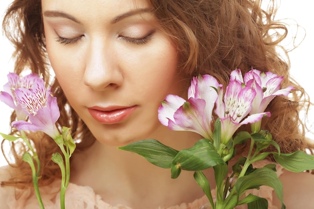 Fille blonde avec fleur rose sur fond blanc