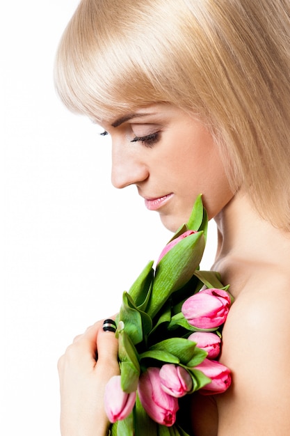 Fille blonde avec des fleurs de tulipes