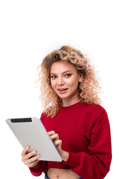 fille blonde frisée avec sur tablette sur blanc