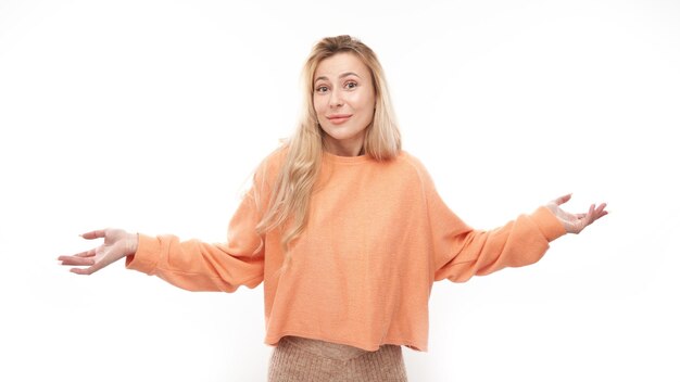 Une fille blonde intelligente dans des mains haussant les mains occasionnelles pense que les doutes prennent une décision isolée sur fond de studio blanc